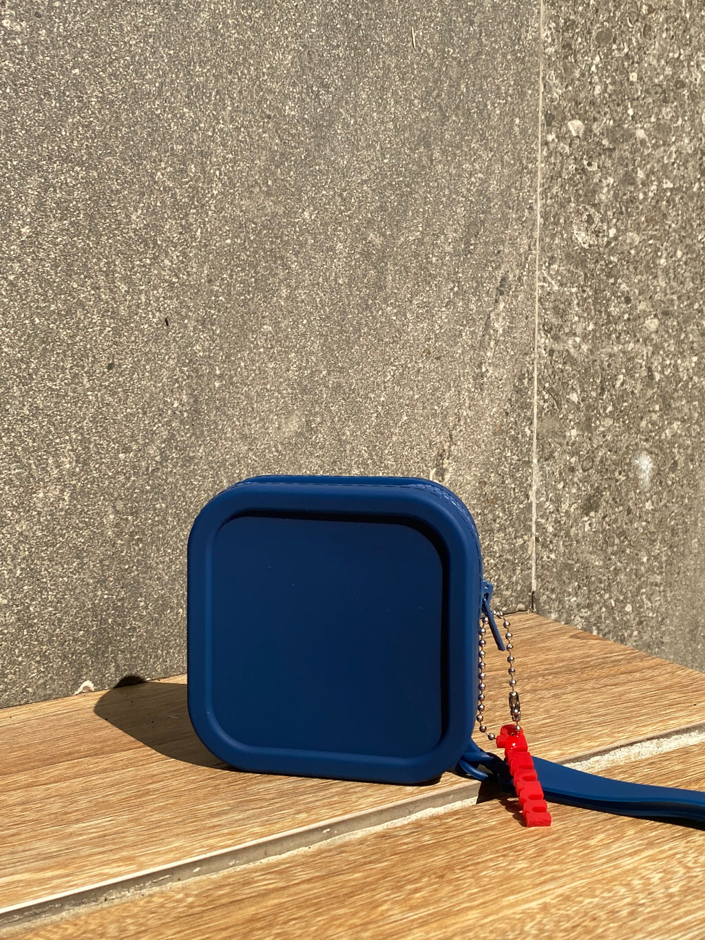 Blue plastic lid with a red handle on a concrete surface