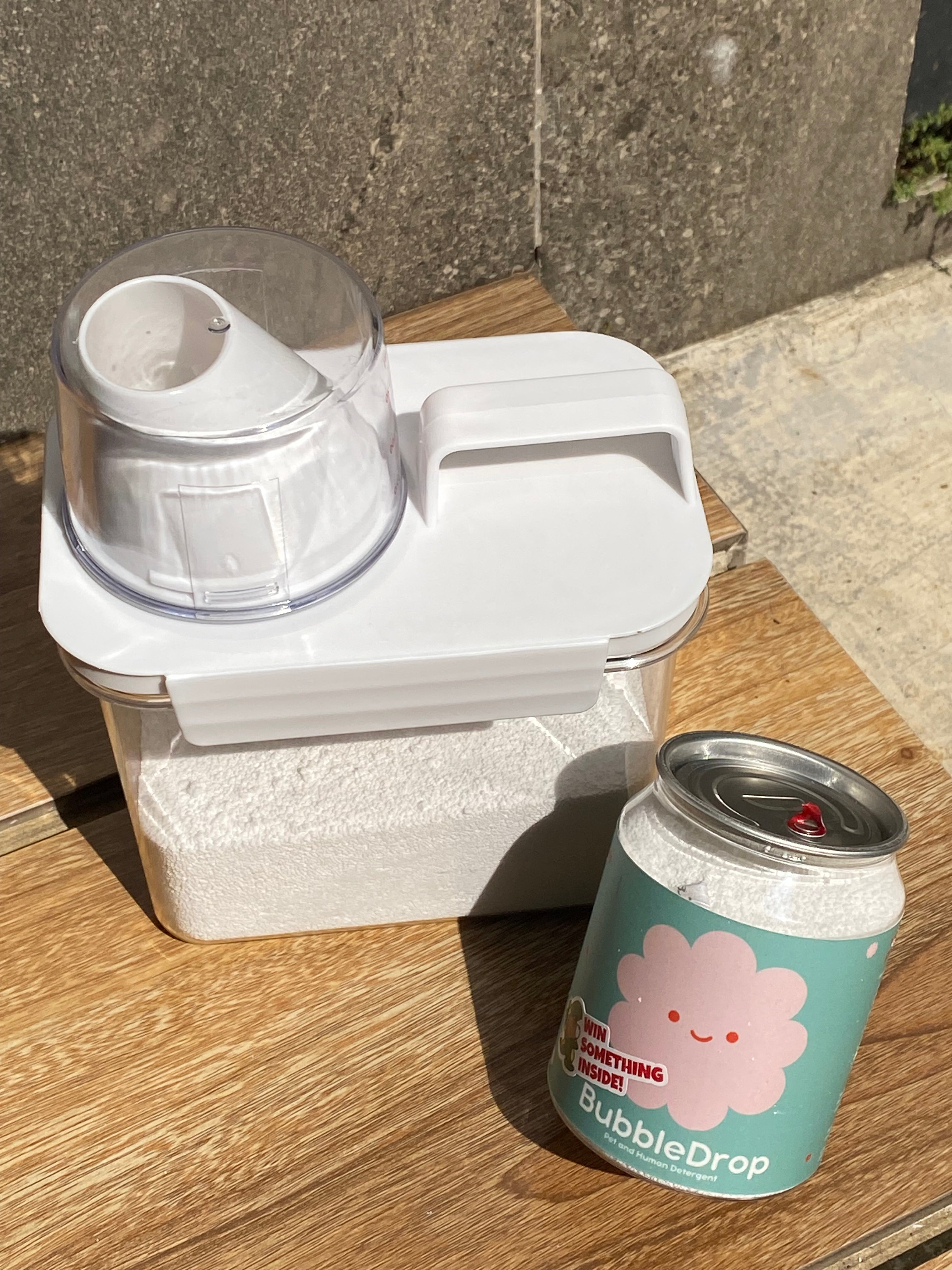 White bubble machine on a wooden surface with a 'Bubble Drop' cup in the background.