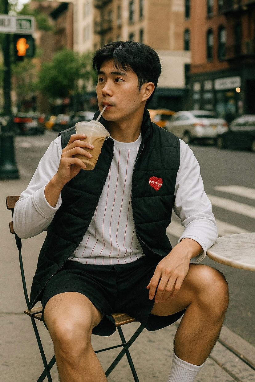 Man sitting on a bench drinking from a cup in an urban setting