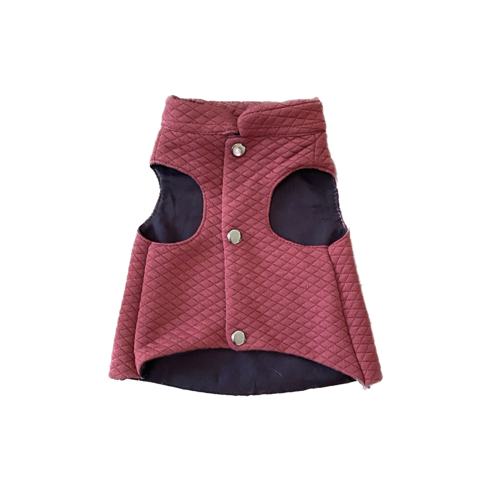 Quilted dog vest in red with black lining on a white background
