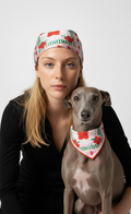 Woman holding a dog both wearing matching bandanas on a white background