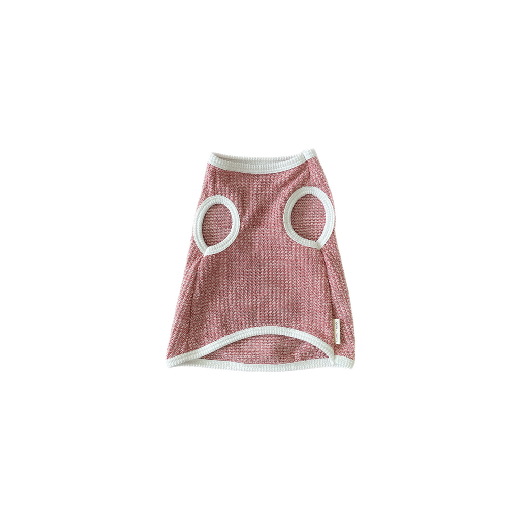 Pink pet dress with circular cutouts on a white background