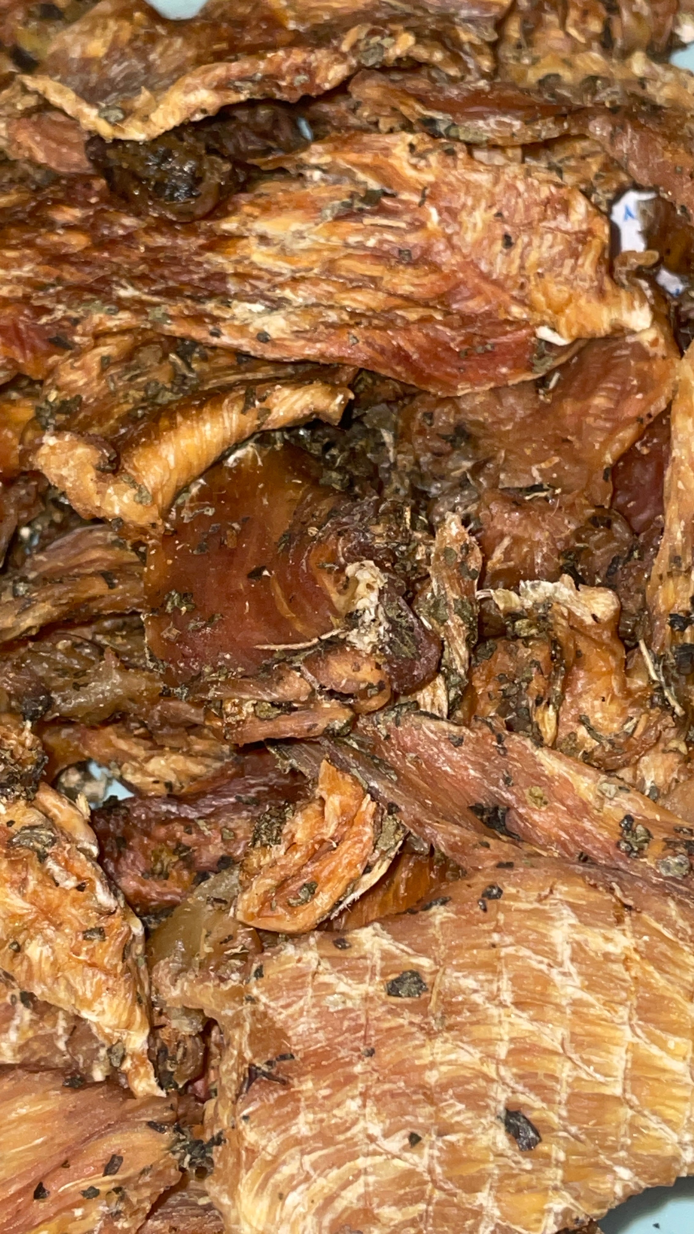 Close-up of dried chicken breast with basil leaves