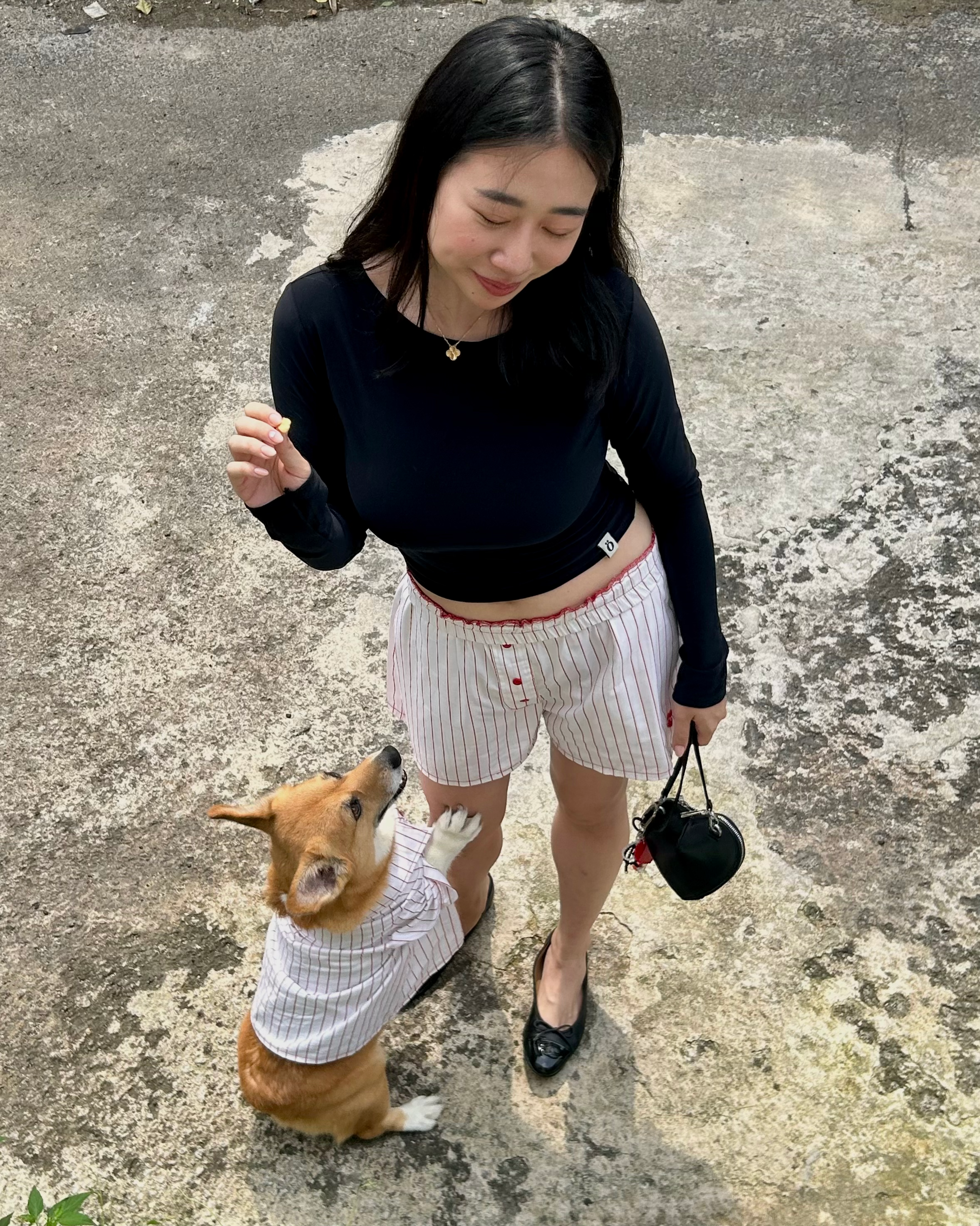 Woman and dog wearing matching outfits on a concrete surface