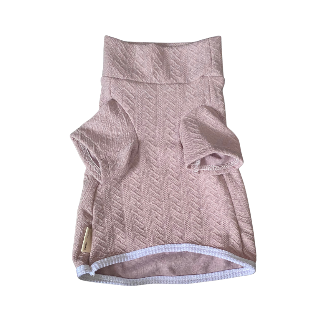 Pink textured dog sweater on a white background