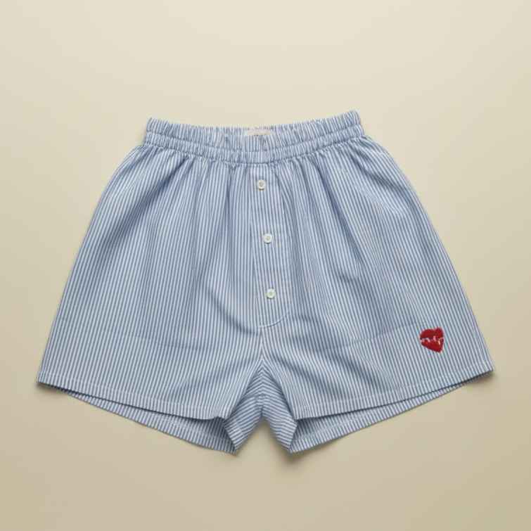Blue checkered boxer shorts with a red heart logo on a beige background