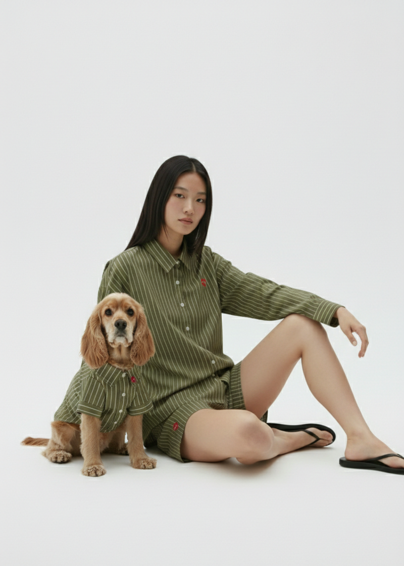 Woman and dog wearing matching green outfits on a white background