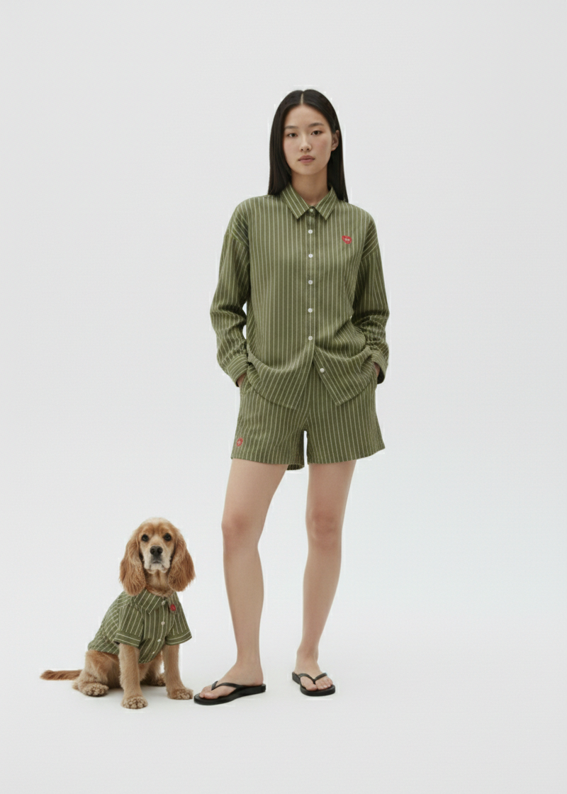Woman and dog wearing matching green outfits on a white background