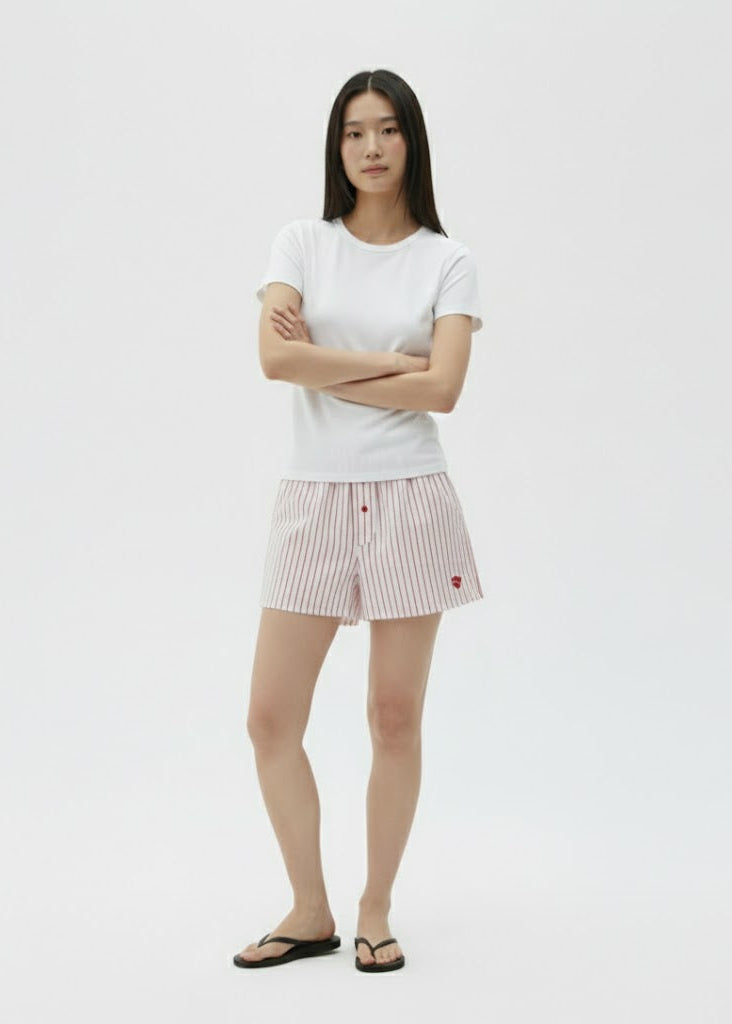 Person wearing a white t-shirt and striped skirt on a plain background